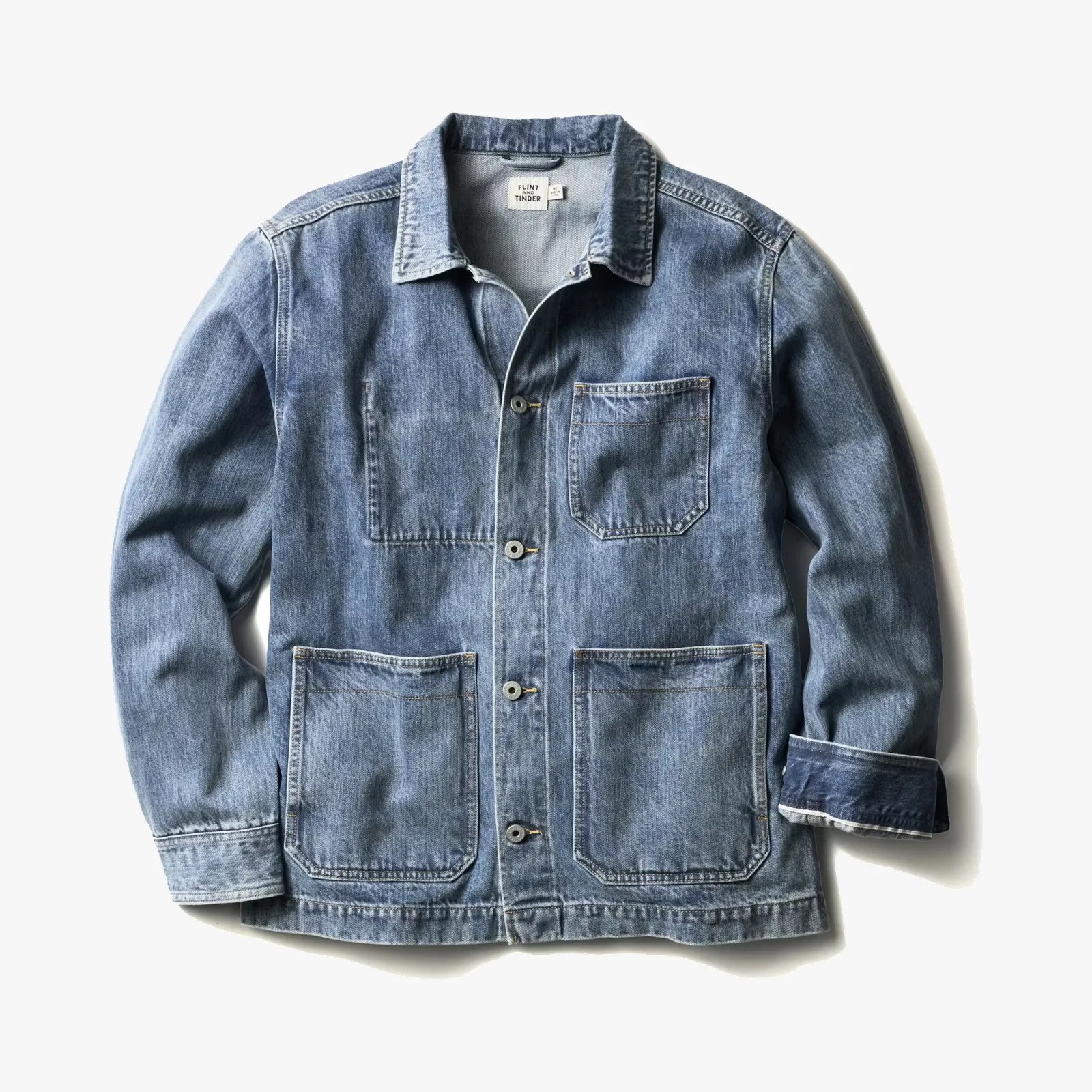 Light blue denim chore jacket with three front pockets and button closure, one sleeve cuff rolled up.