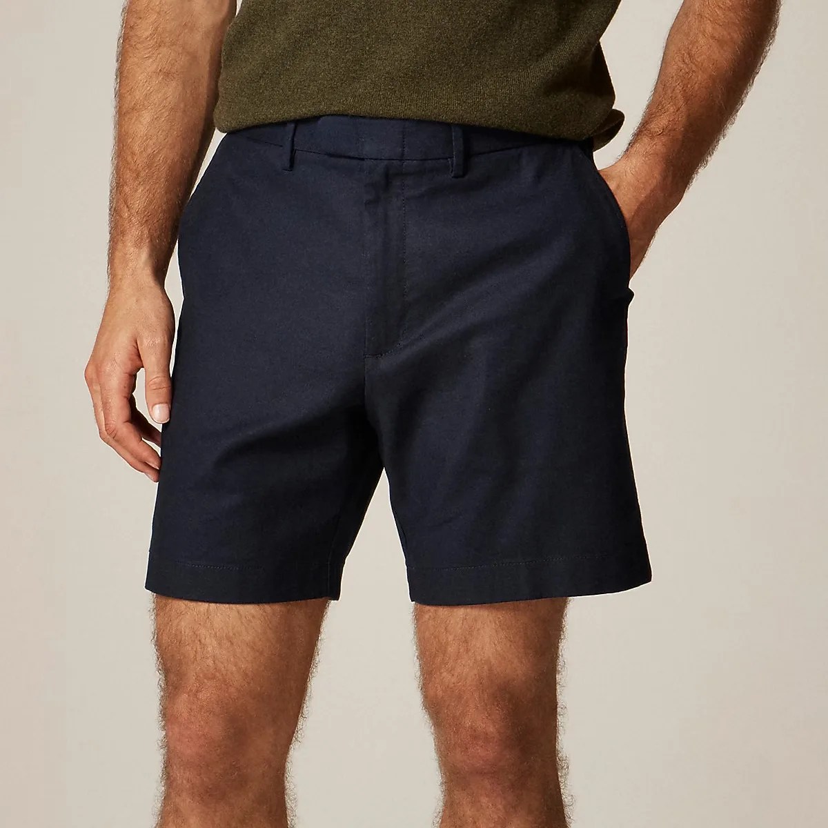 Navy blue tailored shorts worn by a person with hands in pockets.