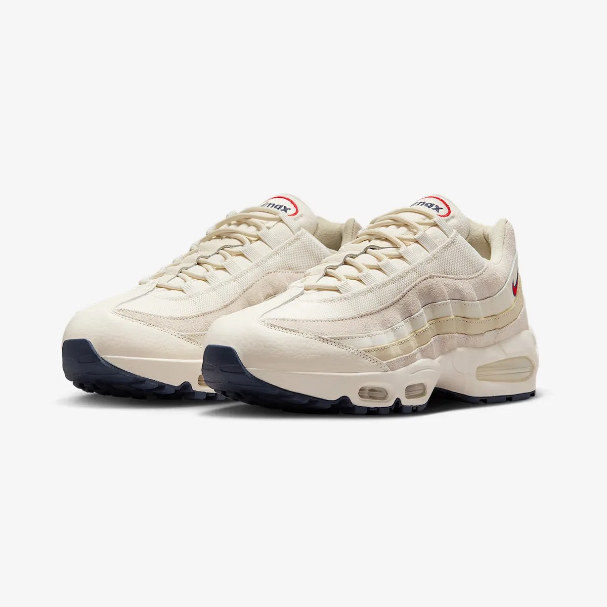 Pair of off-white Nike Air Max 95 sneakers with beige suede accents and navy blue soles.