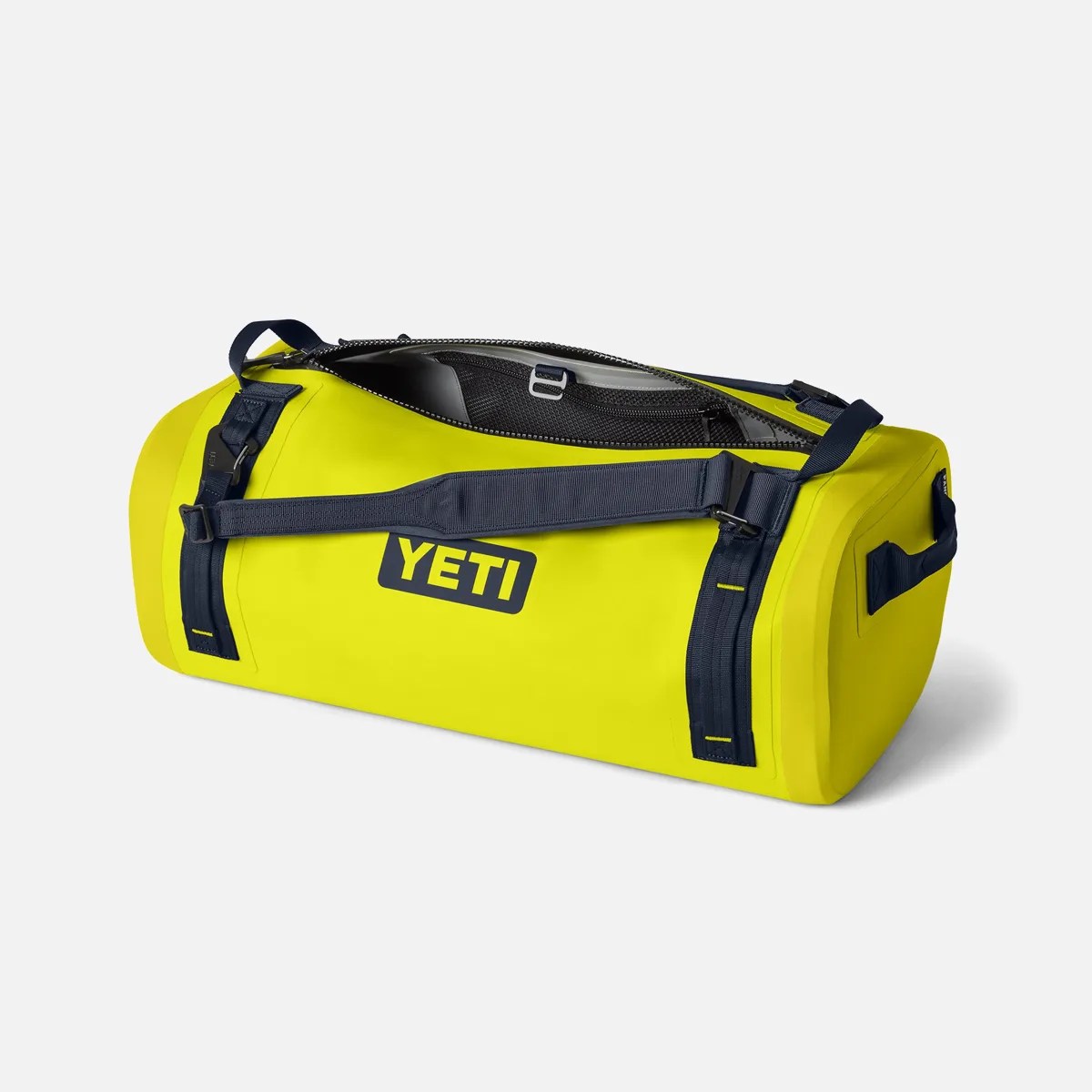 Bright yellow YETI duffel bag with navy blue straps and partially open zipper showing interior mesh pocket.