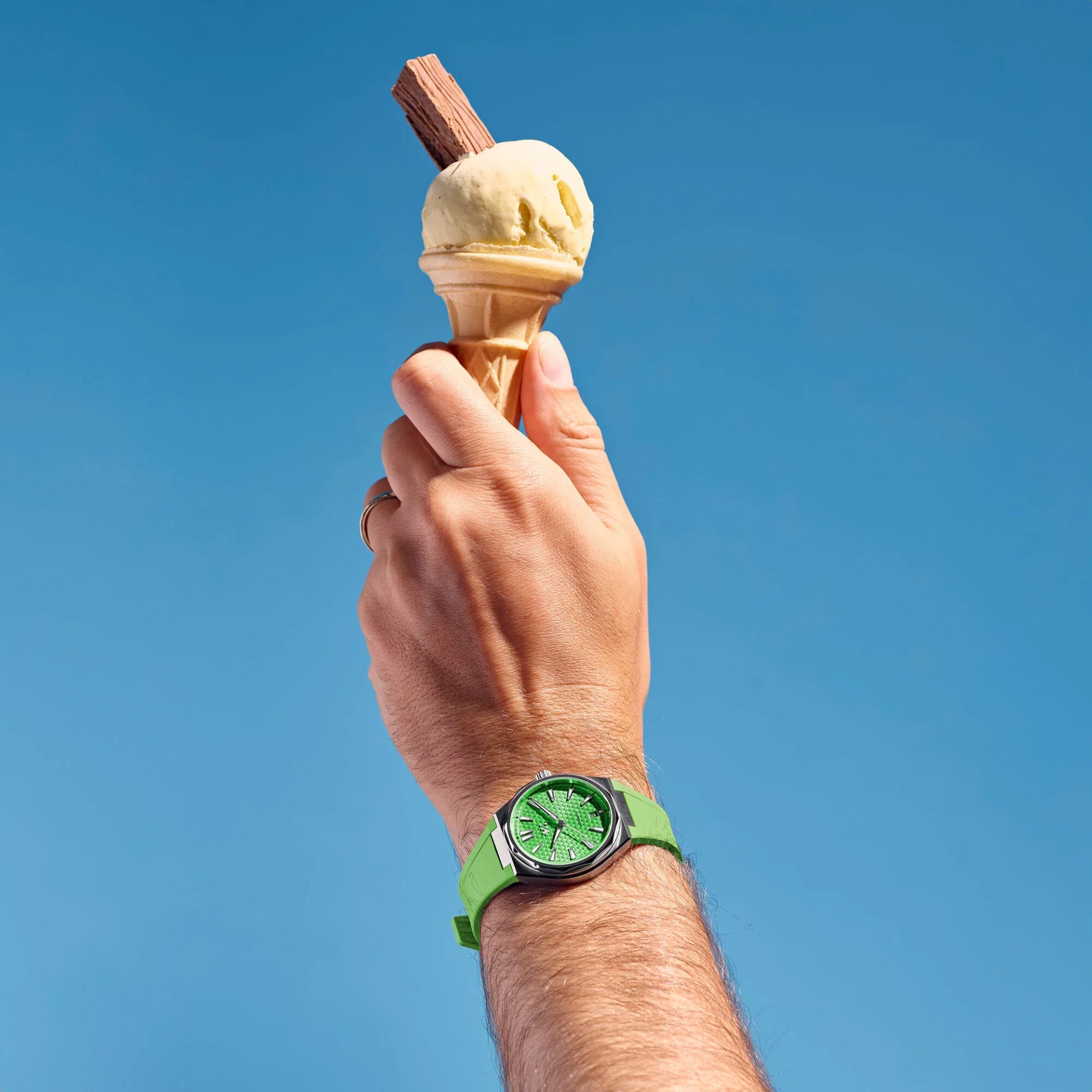 man holding an ice cream cone and wearing a christopher ward watch