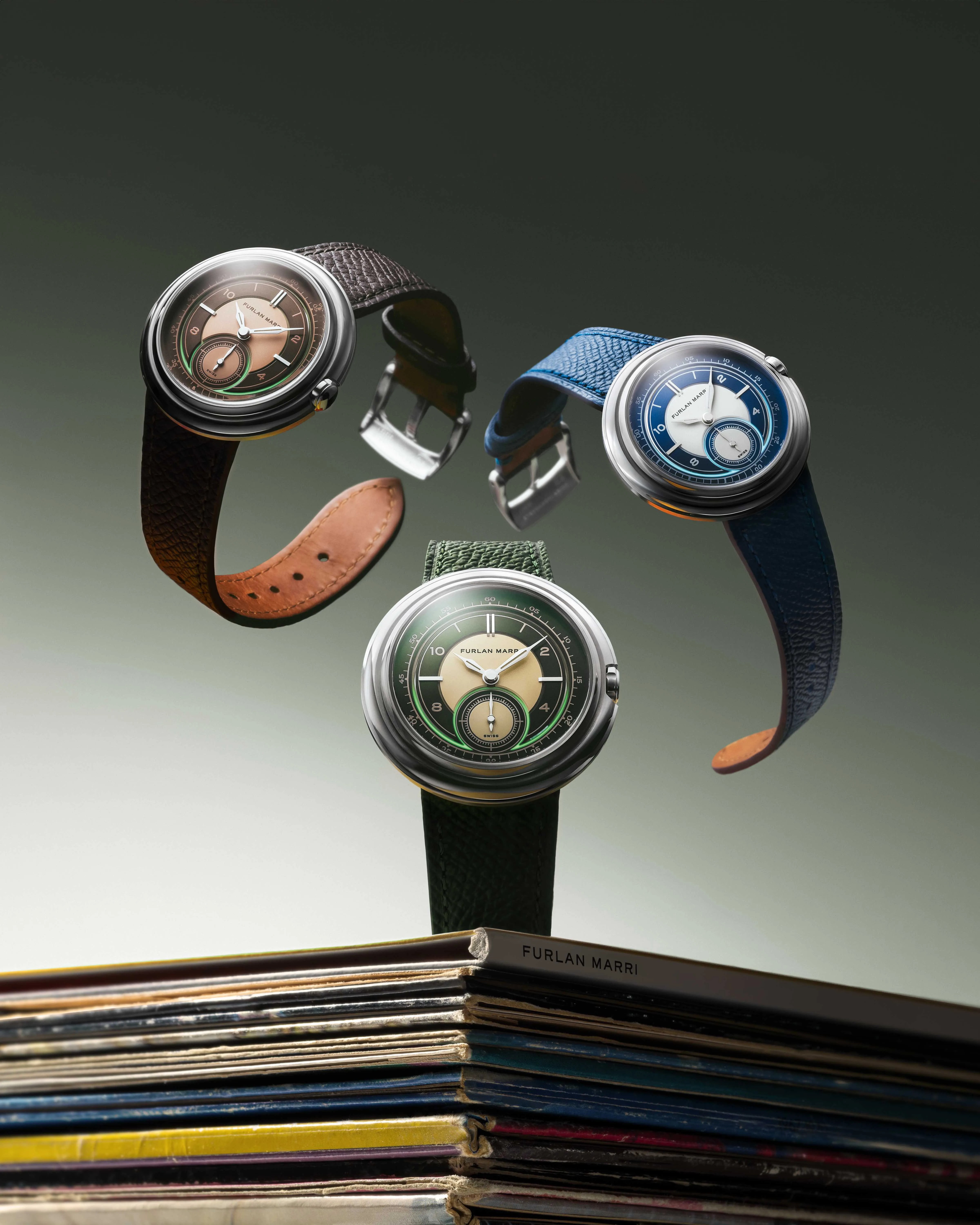 three furlan marri watches float above a pile of magazines