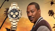 a gold rolex watch is superimposed over a beverly hills cop movie poster featuring actor eddie murphy