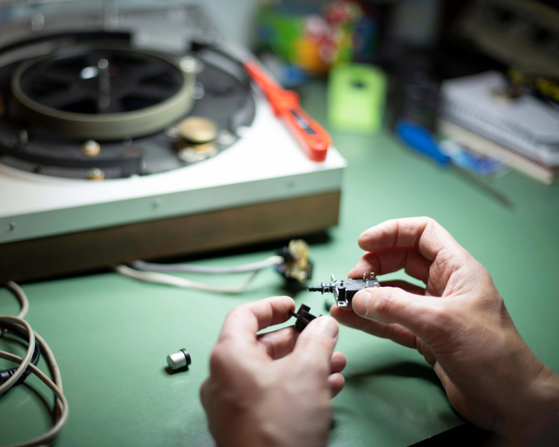 person fixing a vintage turntable