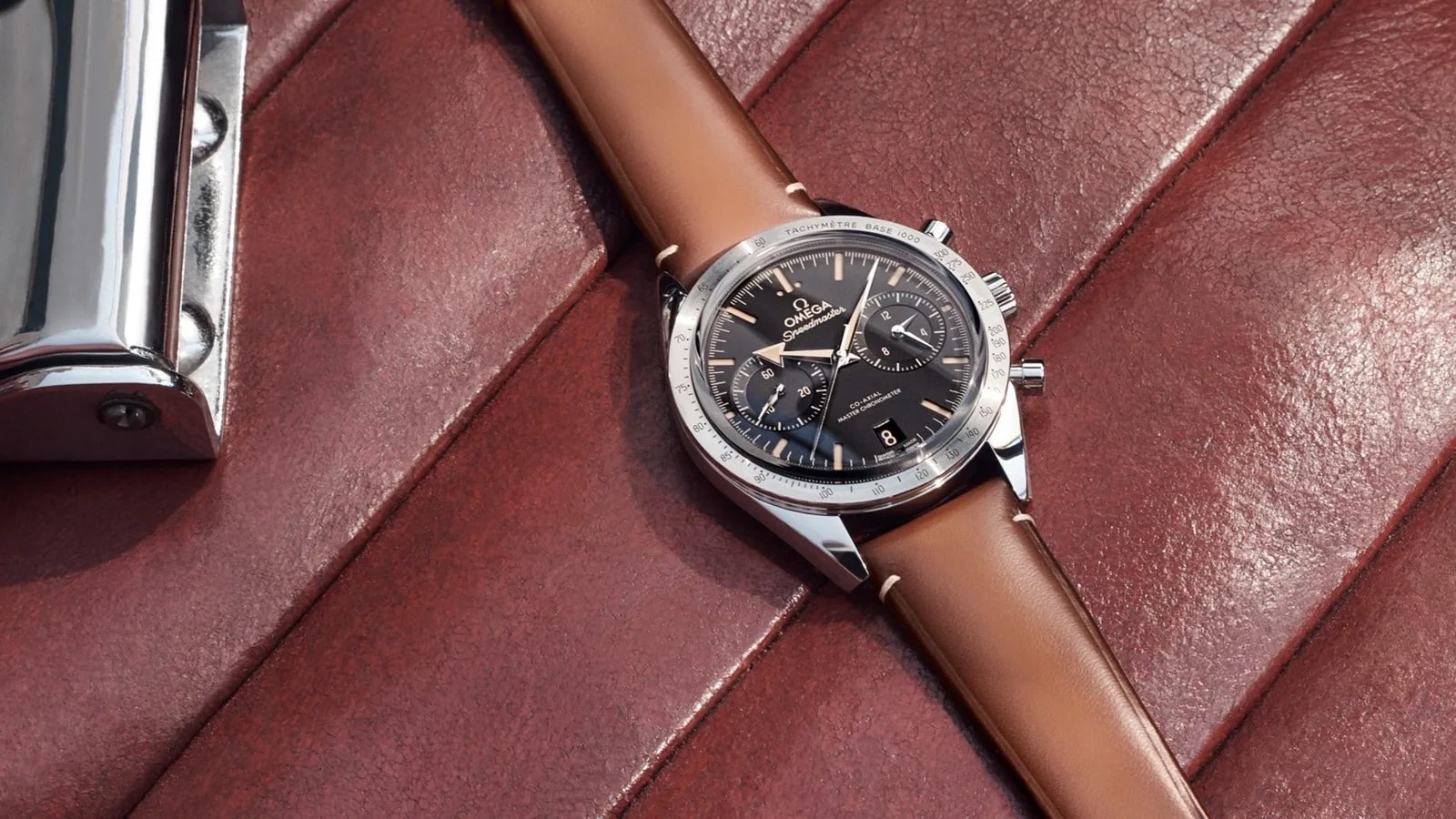 omega speedmaster watch on a leather car seat