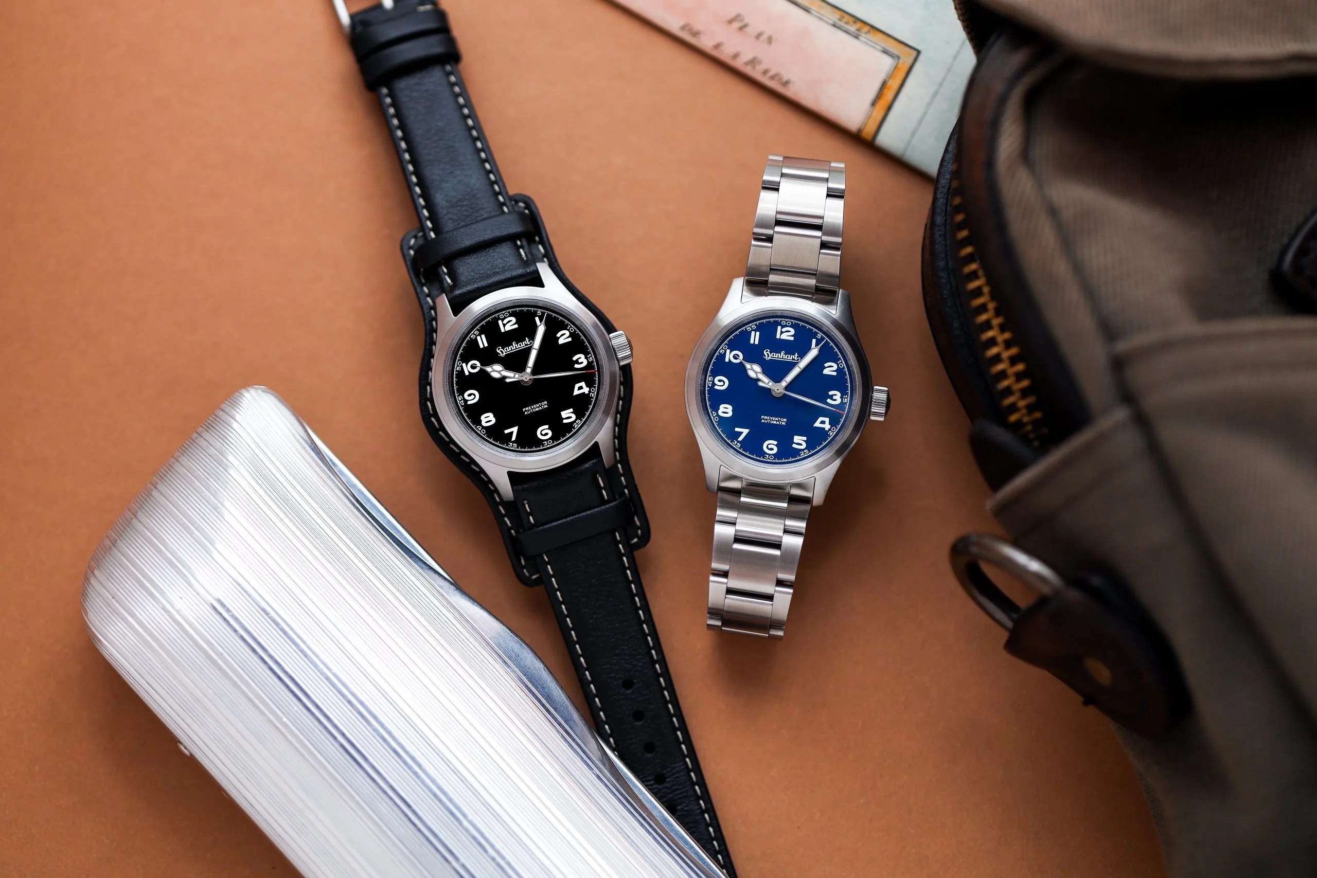 two hanhart watches next to each other on a desk