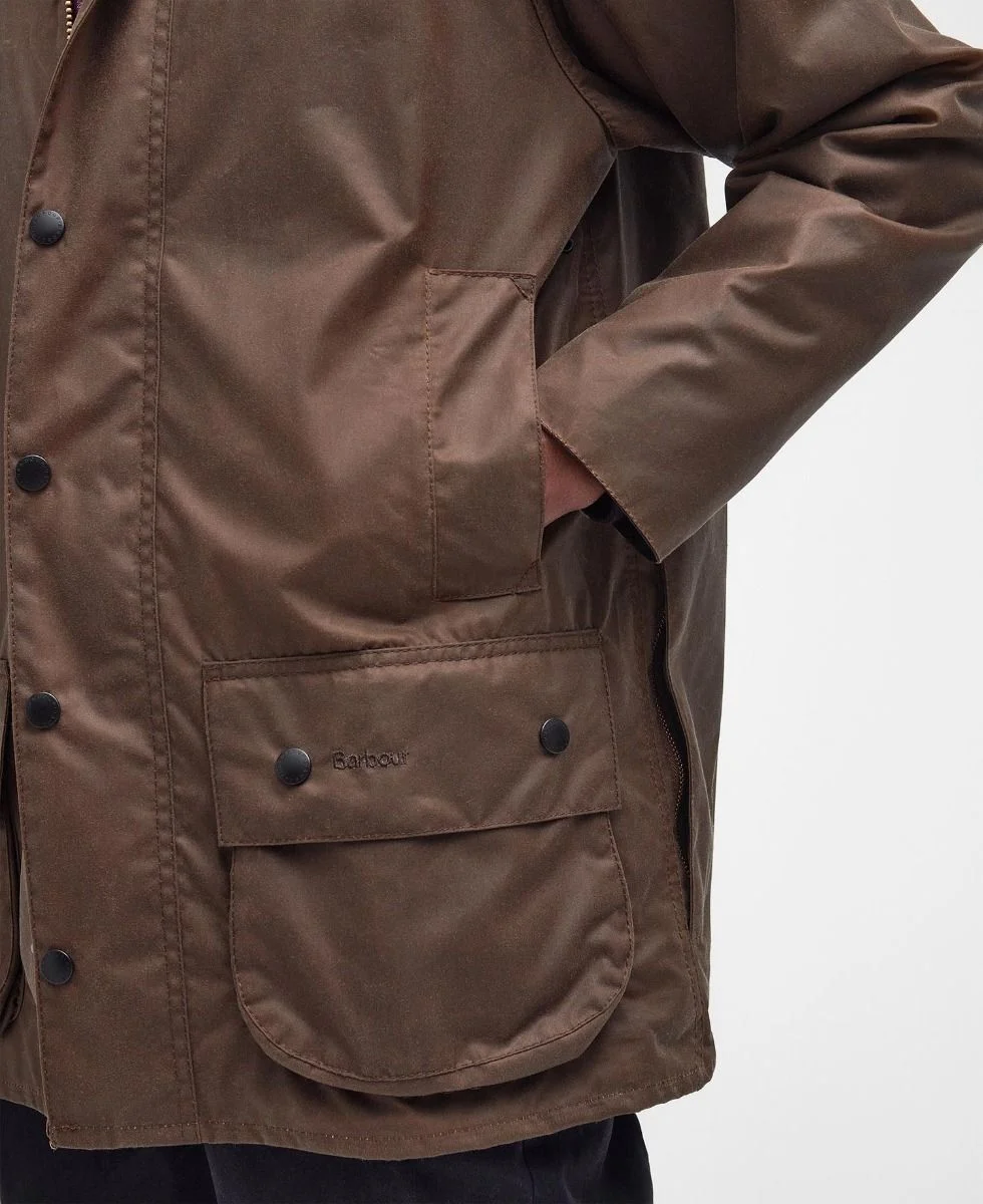 Close up of Barbou&rsquo;sr Beaufort waxed canvas jacket&rsquo;s front pockets with a hand inside