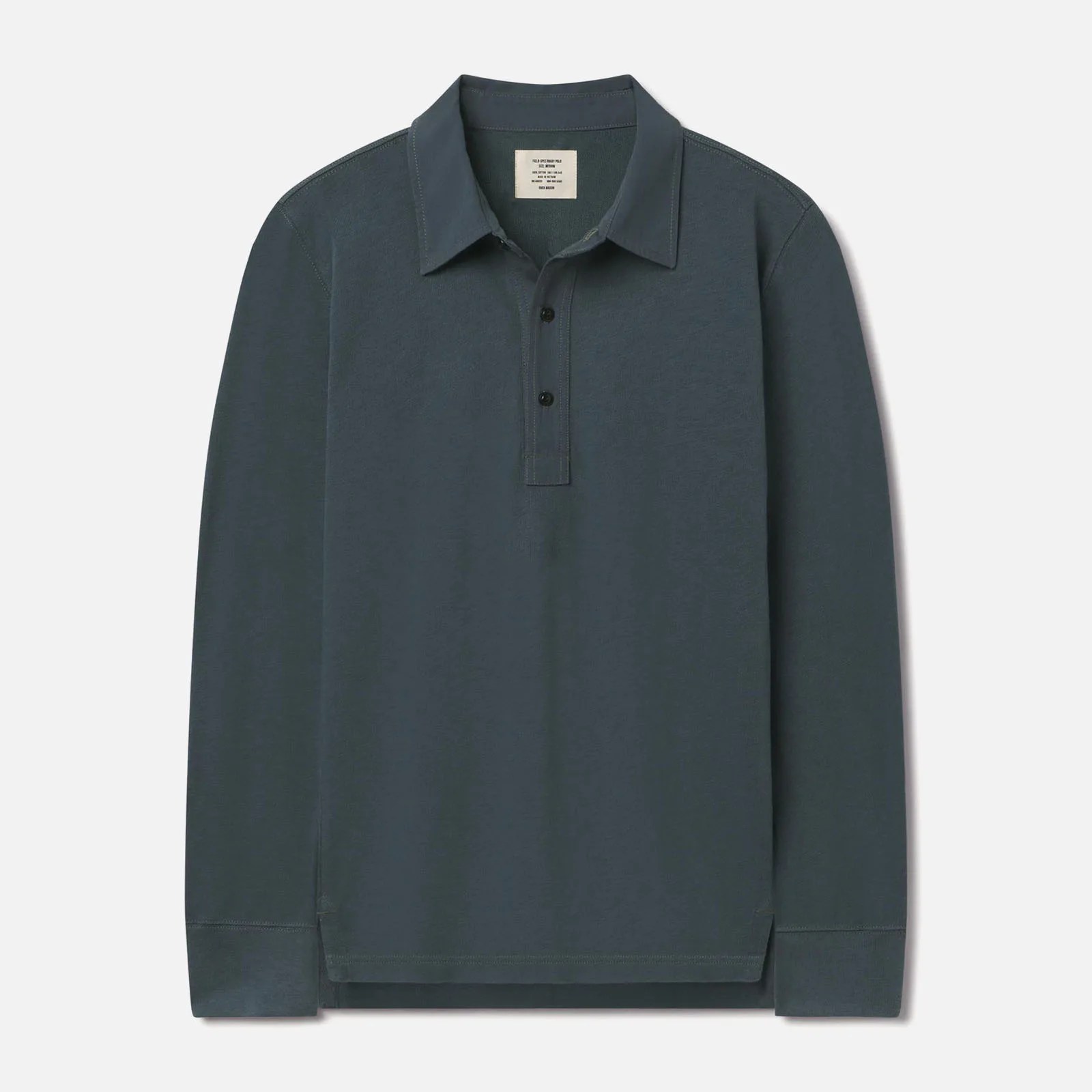 Buck Mason&rsquo;s Field Spec Rugby shirt in a greenish blue color laid flat against a light grey background