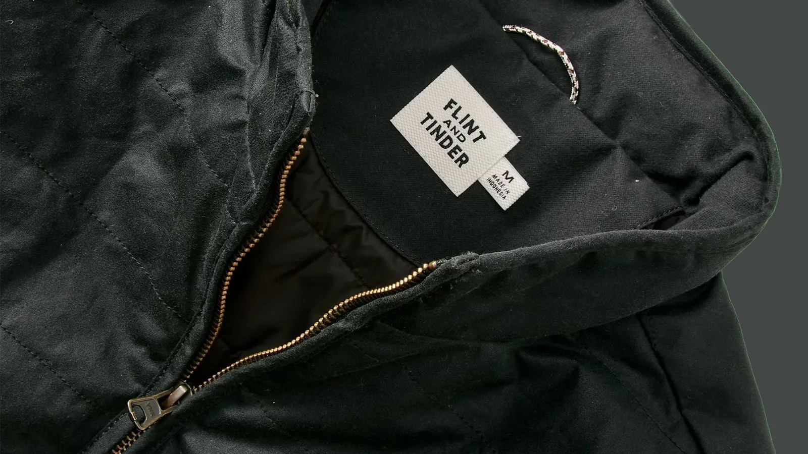A close up of the neck and zipper area of the Flint and Tender York Quilted Waxed Jacket