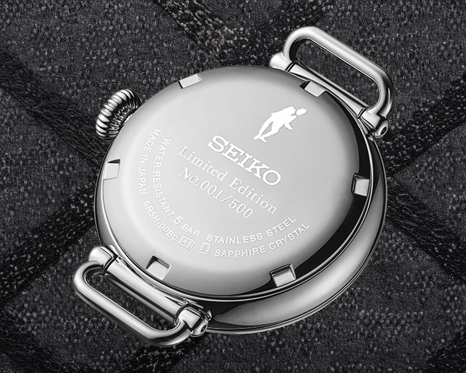 seiko watch caseback against a black cloth background