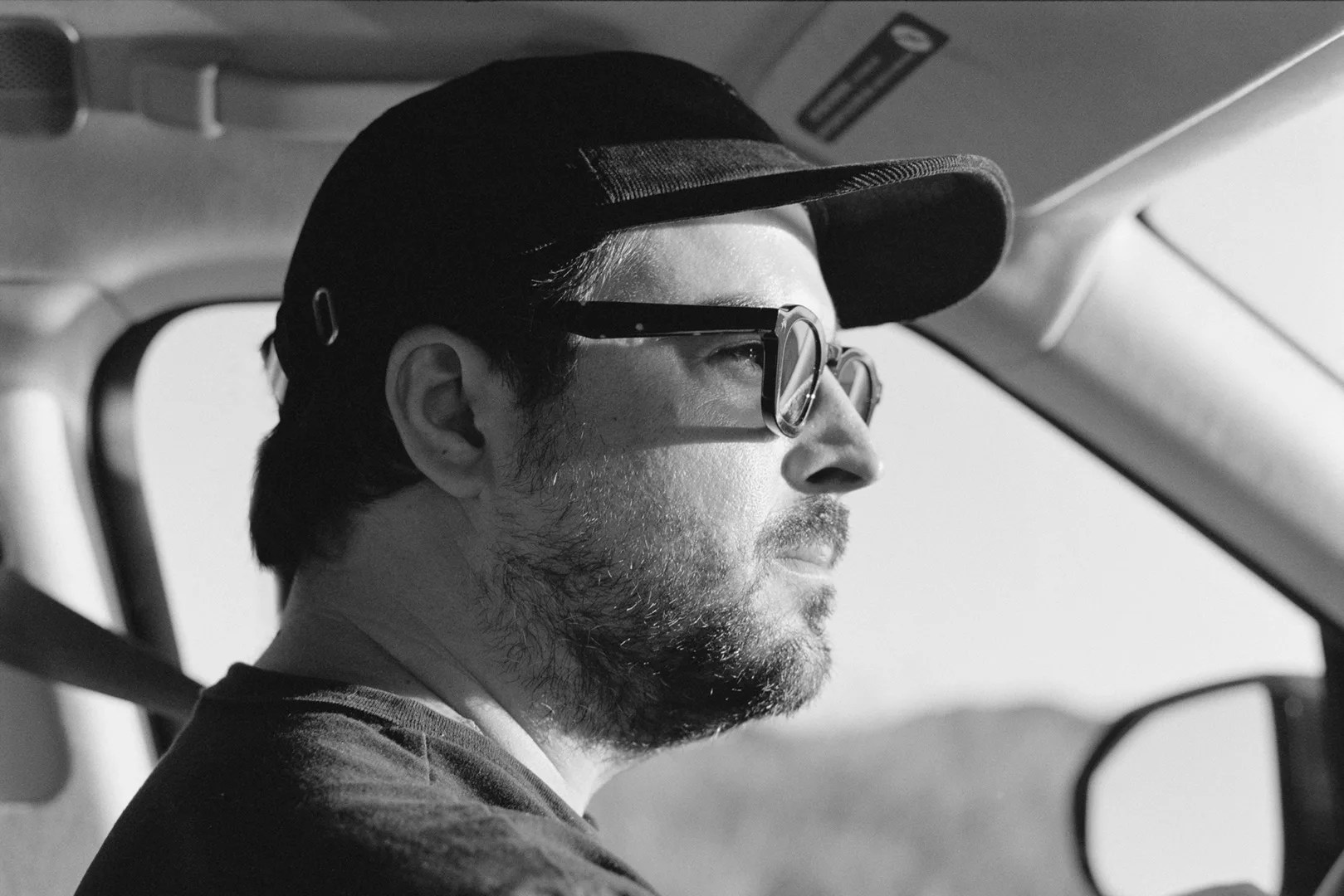 man driving car with sunglasses profile view