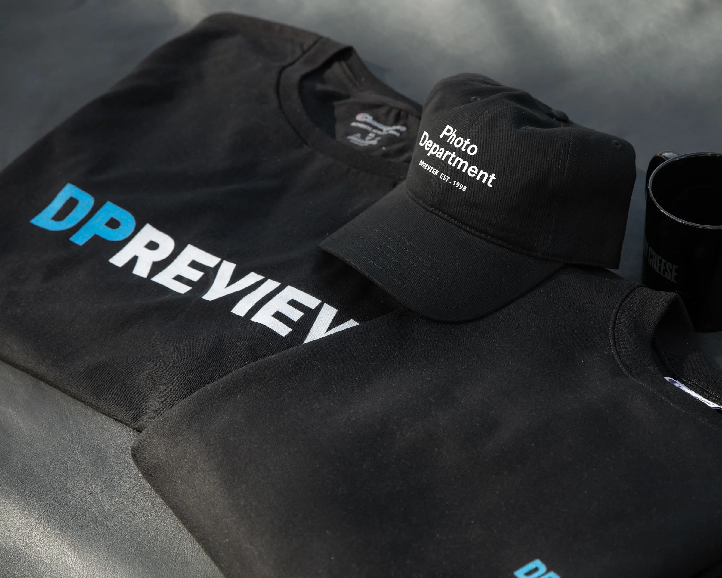 collection of items from the dpreview pop-up shop including a sweatshirt, tee shirt, and hat