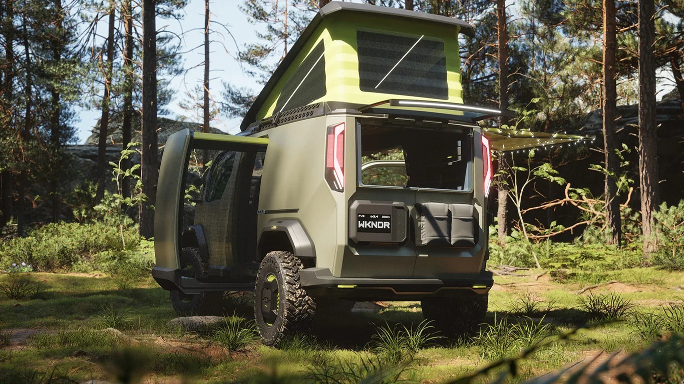 the kia pv5 wkndr ev camper van concept parked in the woods seen from behind