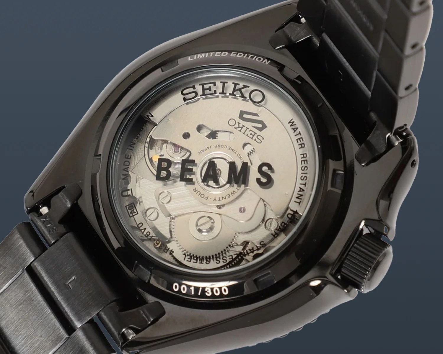 the caseback of a black seiko 5 sports beams watch showing its mechanical movement