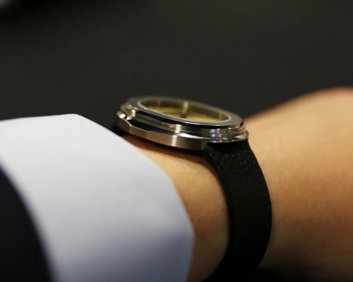 a serica dress watch on a mans wrist seen from the side