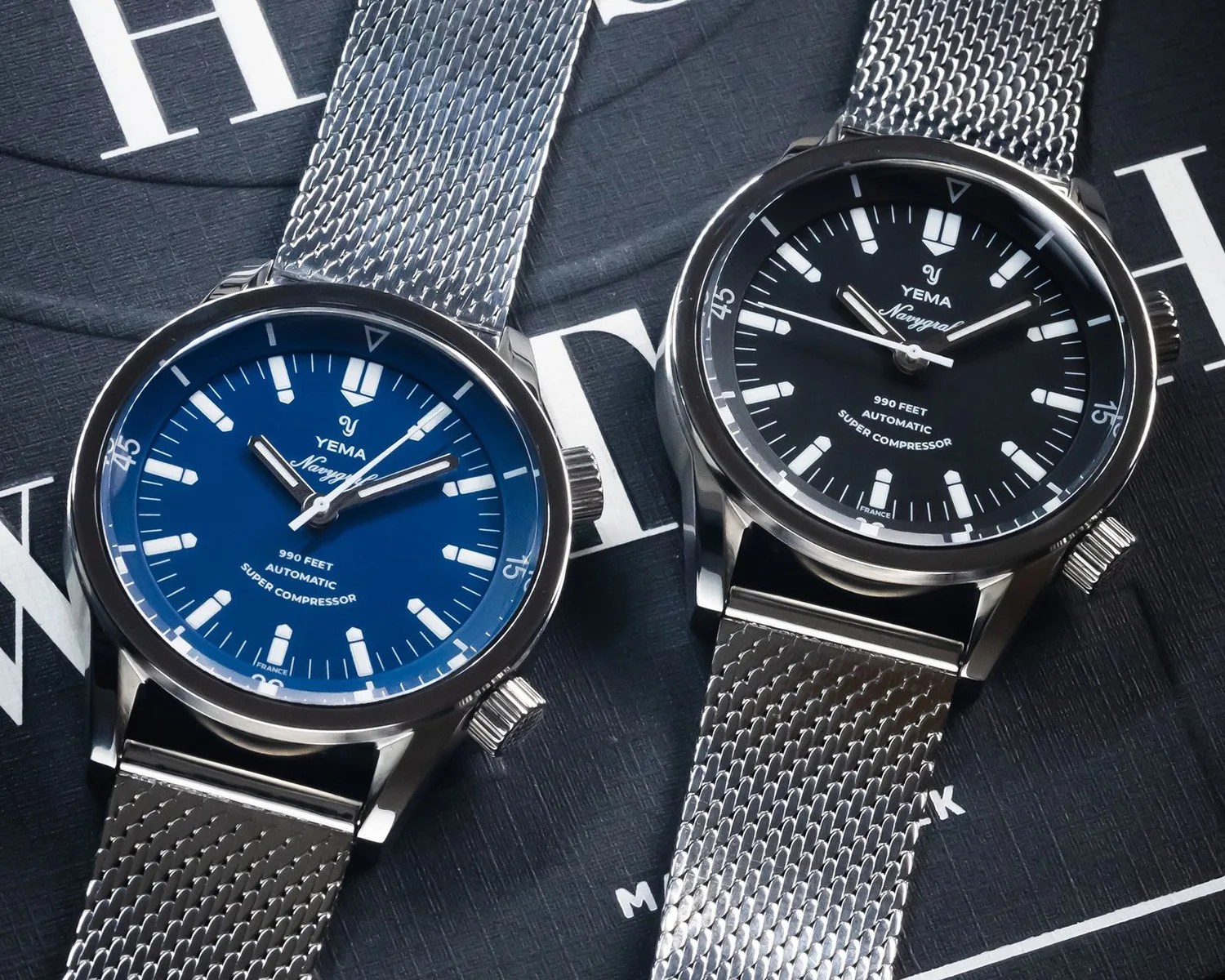 two yema super compressor dive watches on a book