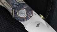 Closeup of Bestech Prydwen knife pivot on black fabric background