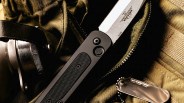 Closeup of Emerson A 100 Automatic Knife on tactical pack next to dog tags