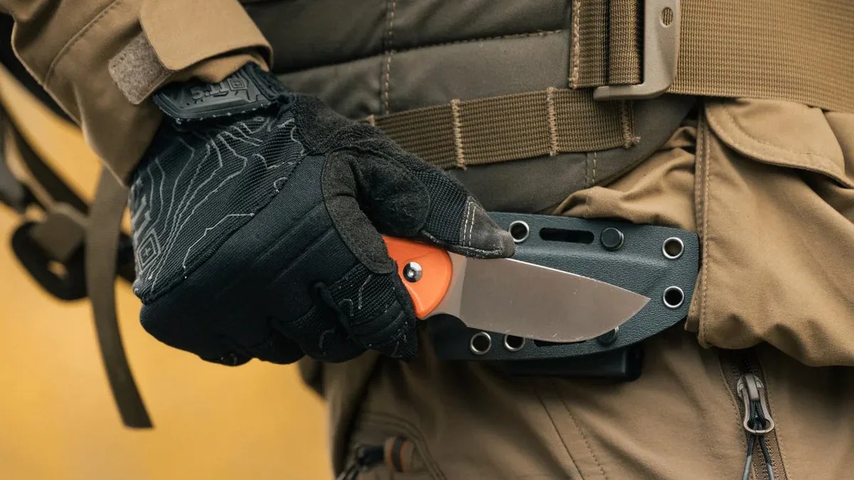 person holding Civivi knife with orange handle