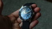 a hand holds a glashutte original dive watch