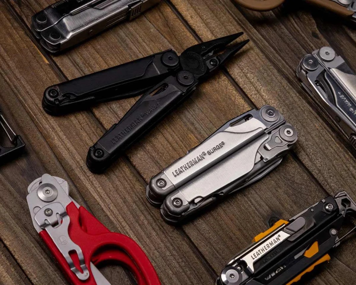 A collection of leatherman multi-tools on a wood table