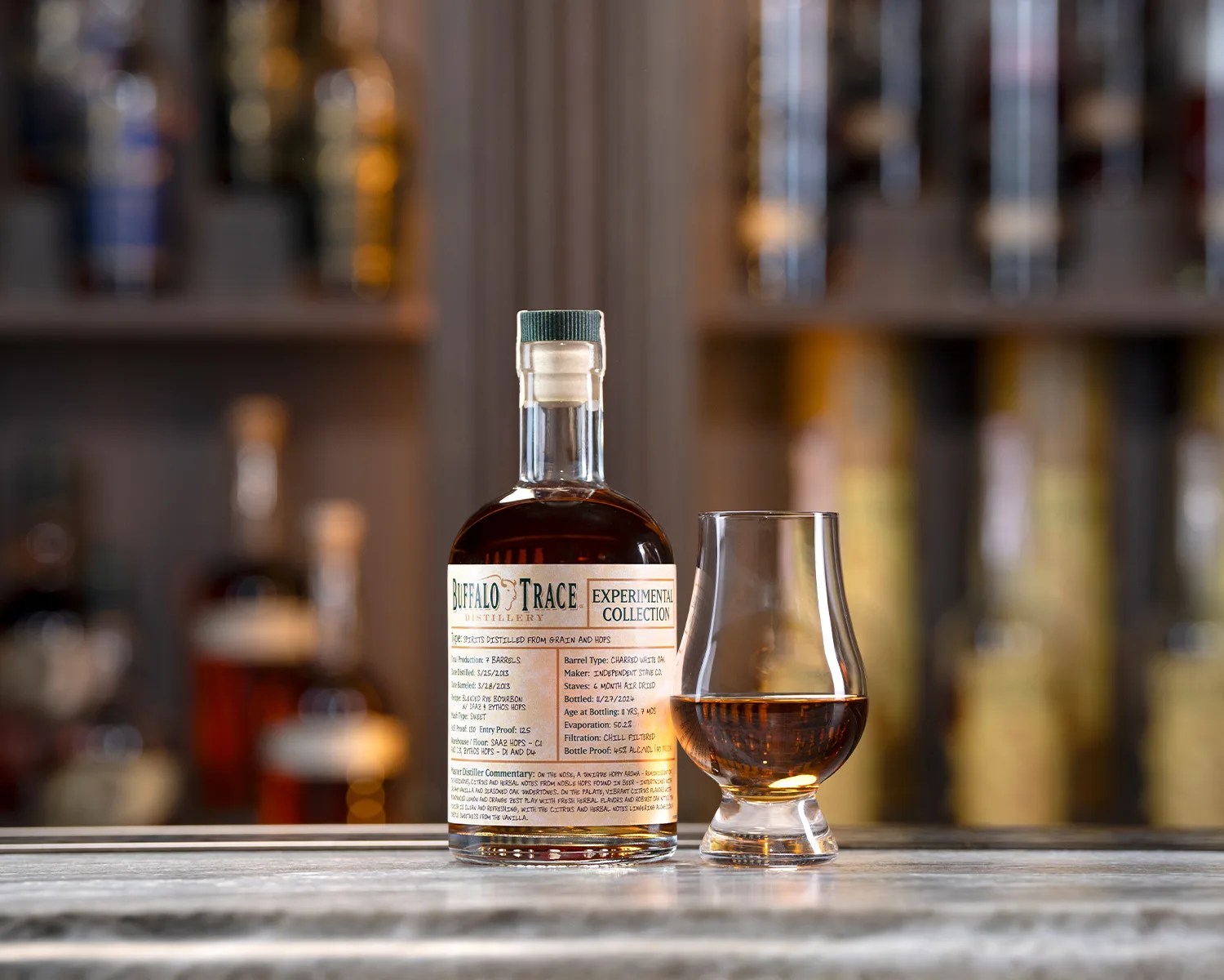 a buffalo trace whiskey bottle next to a glass of whiskey on a bar