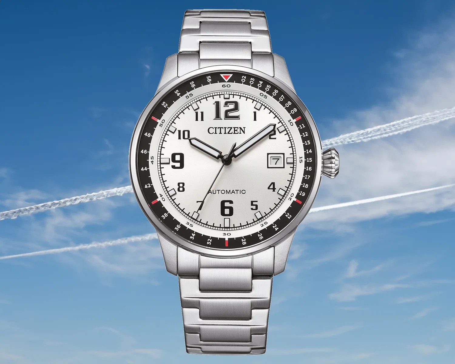 a citizen tool watch superimposed over a sky with contrails