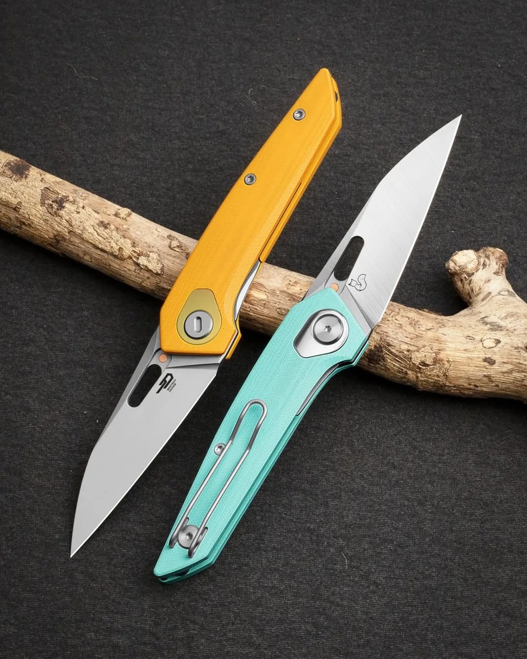 Bestech VK Void G10 knives on gray background leaning on tree branch