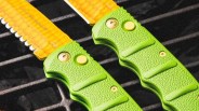 Closeup of Böker Kalashnicob auto knives on grill