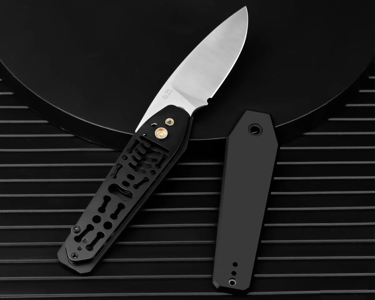 Black Kizer Tomb knife on black background with scales taken off showing skeleton pattern underneath