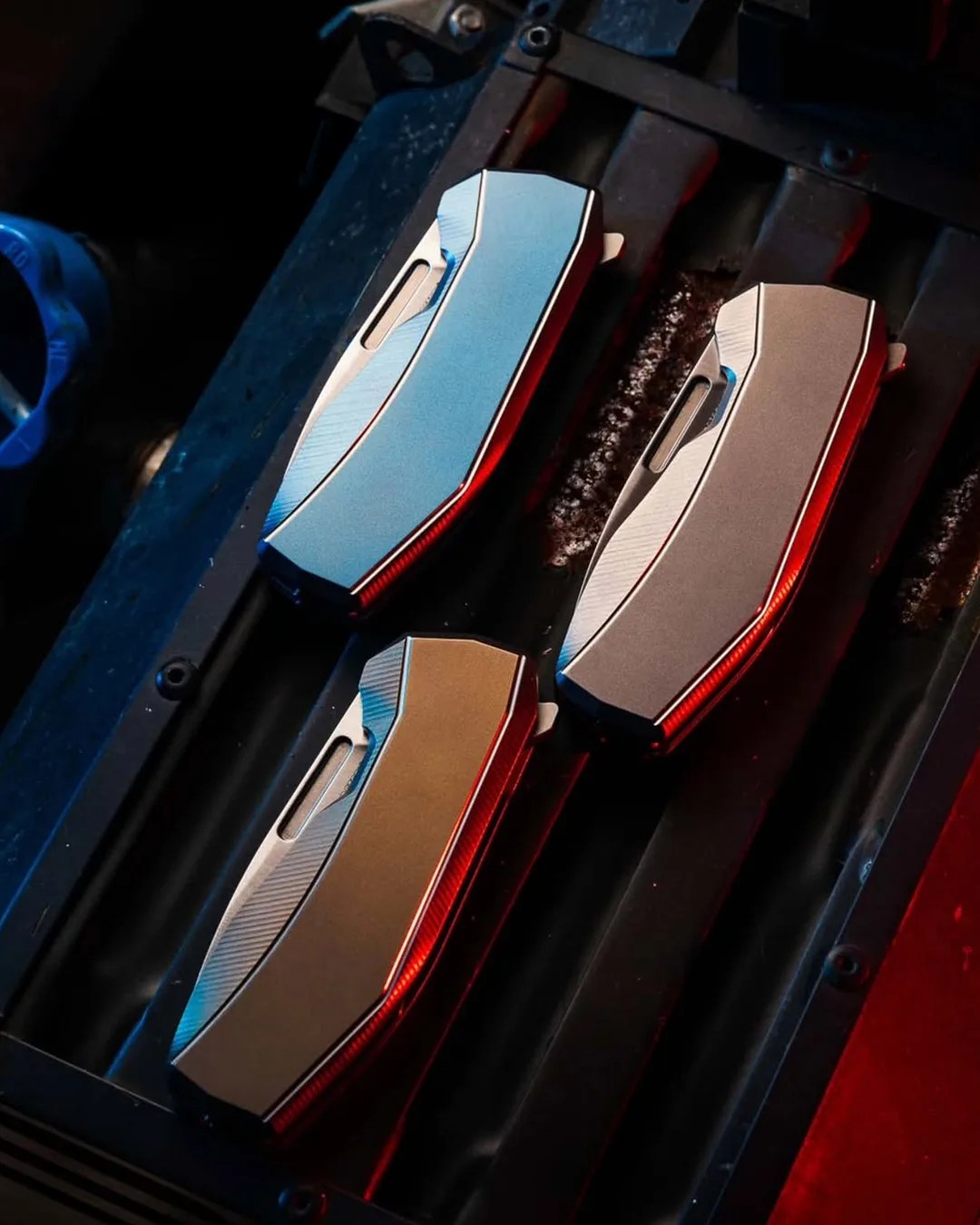 Three Lionsteel N1 knives closed on industrial surface