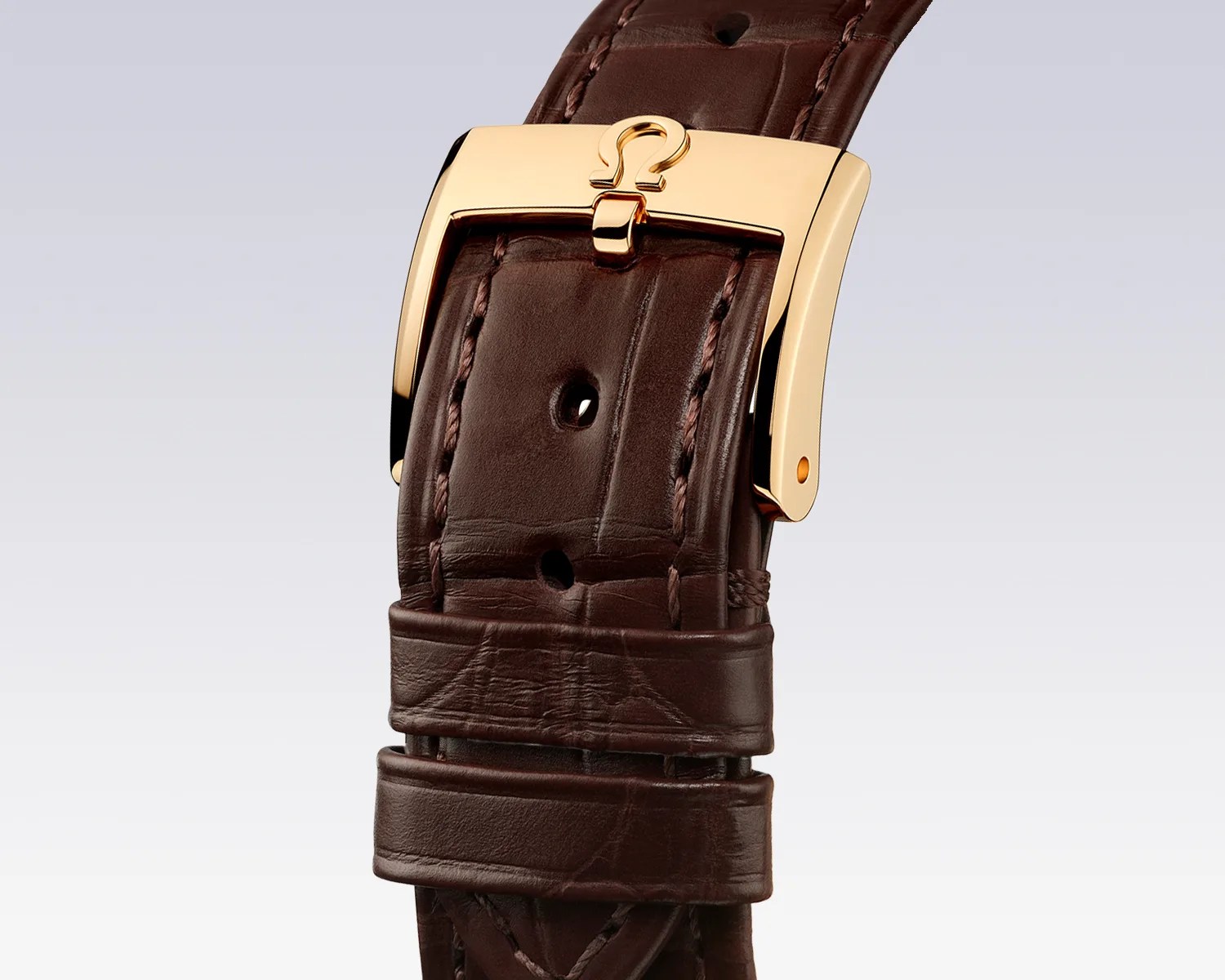 the leather strap and gold buckle of an Omega dress watch