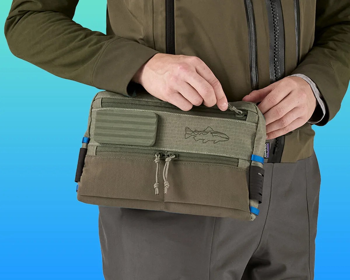 person wearing Patagonia Stealth Switch Pack on blue-green background