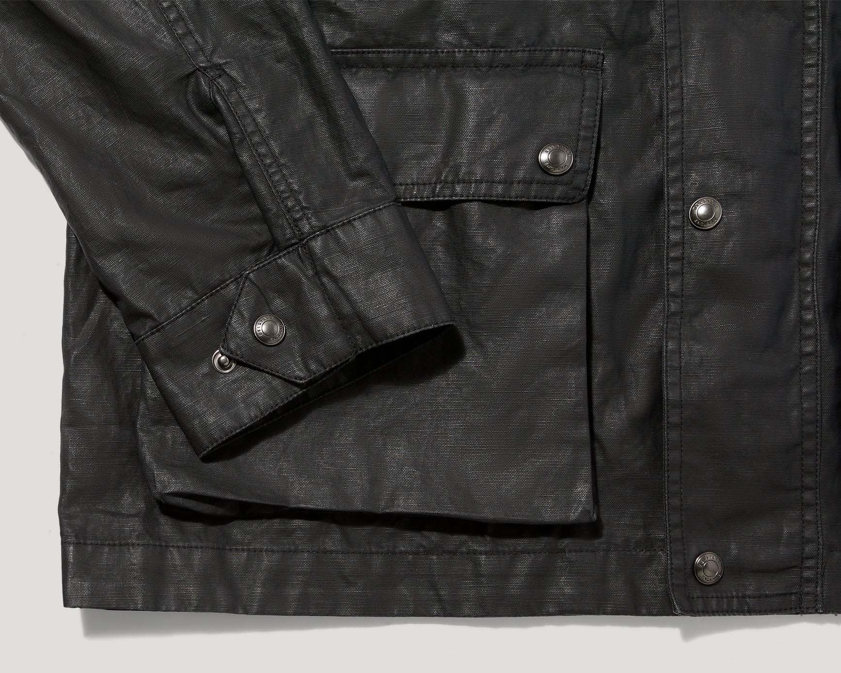 the cuff and pocket of a black moto jacket