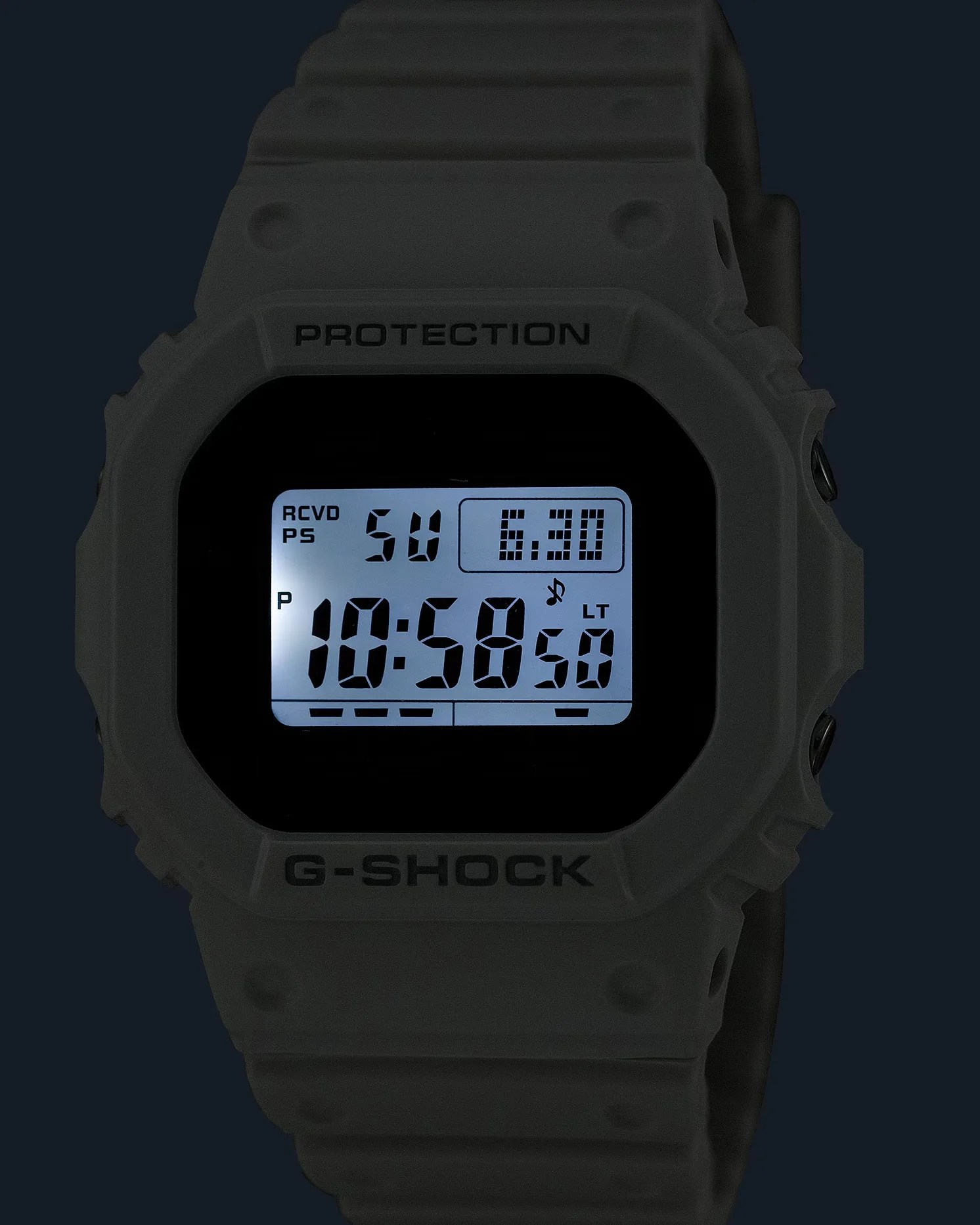 a white g-shock watch with a dark background and the dial illuminated