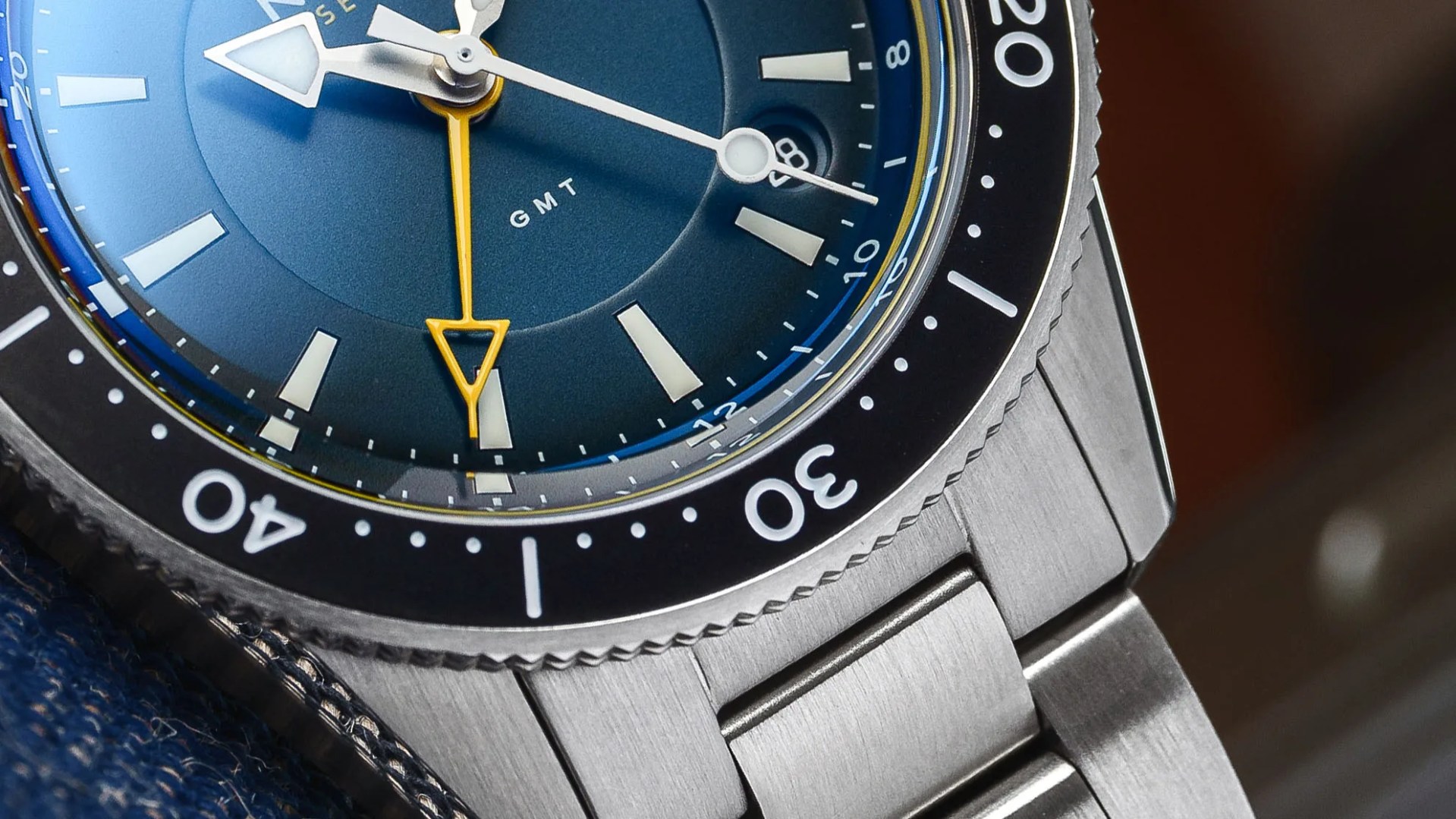 close up of a steel dive watch with a blue bezel