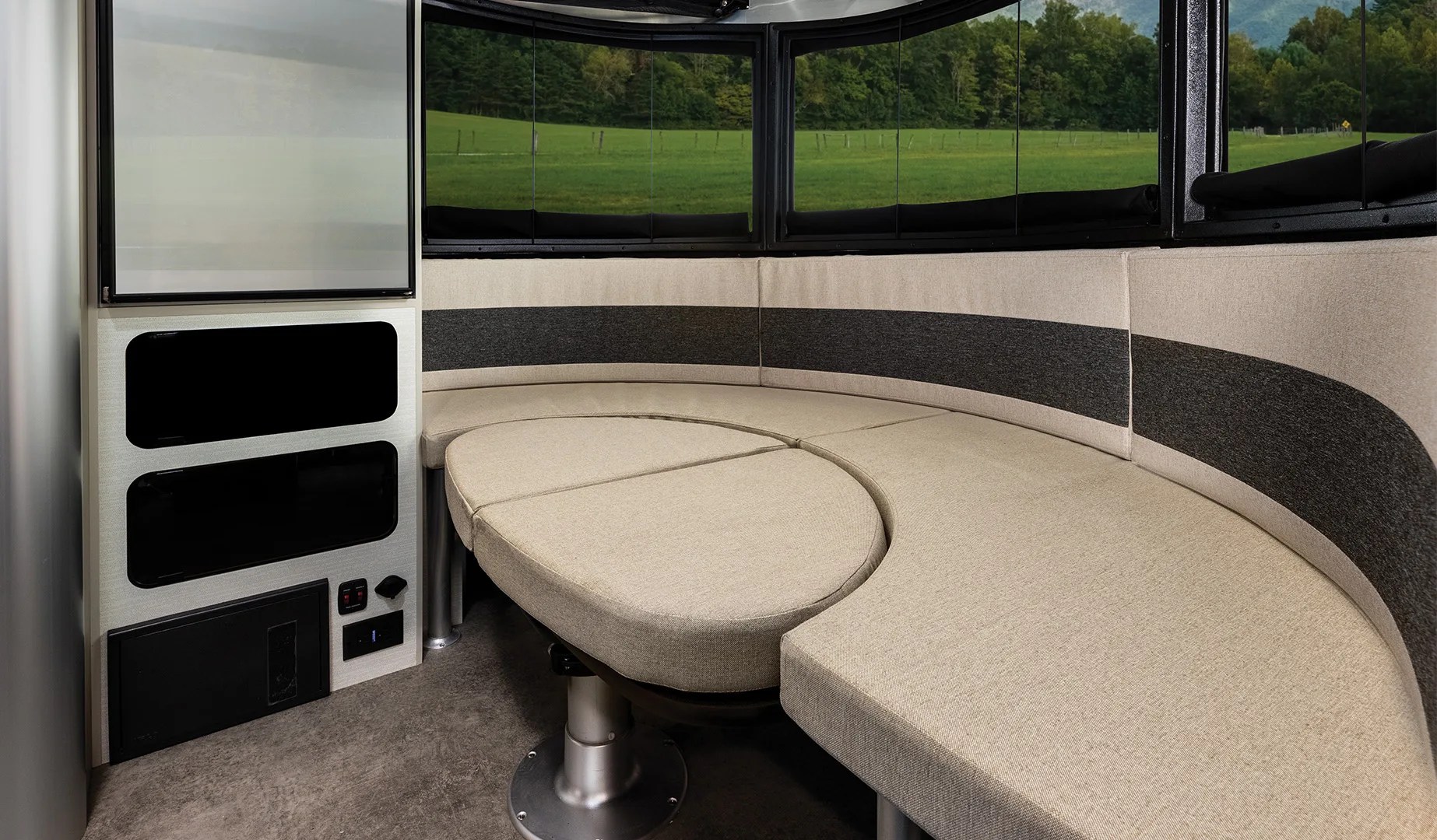 An interior image showing the gallery seating area of the Airstream Basecamp Xe adventure trailer which can convert into a sleeping area.