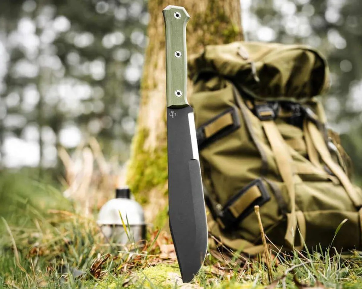 Böker Plus Northwood Bowie in front of hiking pack and canteen in forest