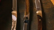 Closeup of three Buck The 55 Knife Customs
