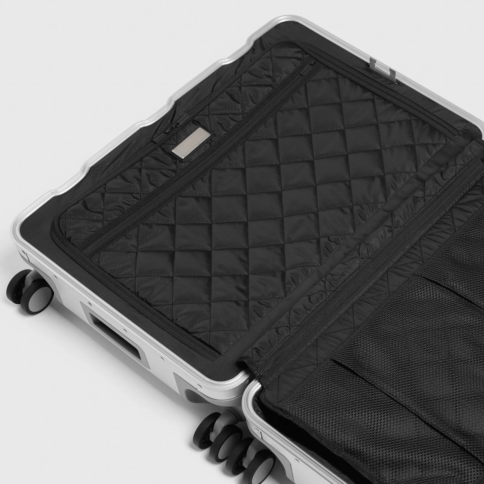 A shot of the zippered fabric interior of a Monos Aluminum hard-sided suitcase.