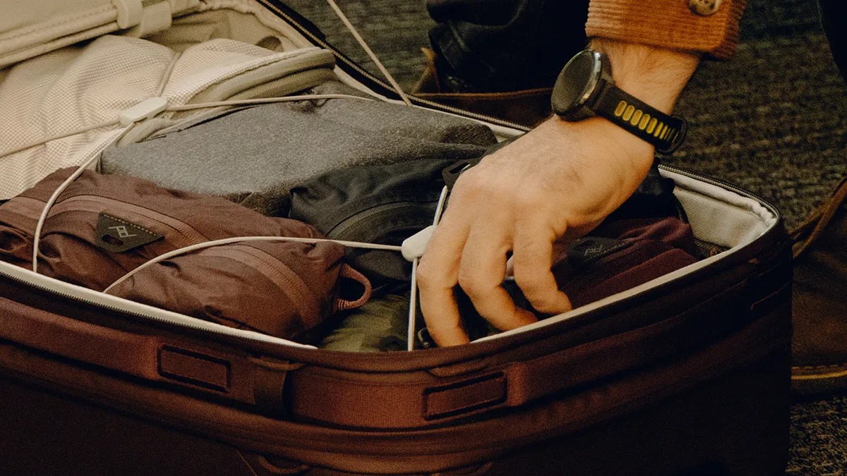 Man's hand reaching into interior of Peak Design Roller Pro Carry On closeup