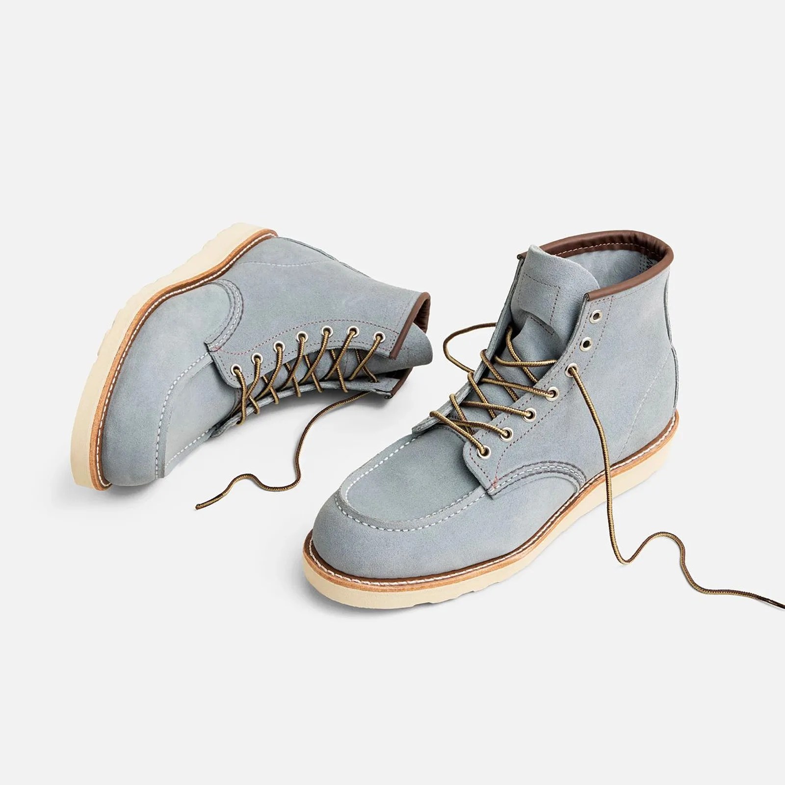 A pair of Red Wing Heritage Classic Moc 6-inch boots in dusty blue Abilene leather sitting against a light grey background. One show is shown standing up, while the other is sitting next to it, lying on its side. The laces of both shoes are untied.