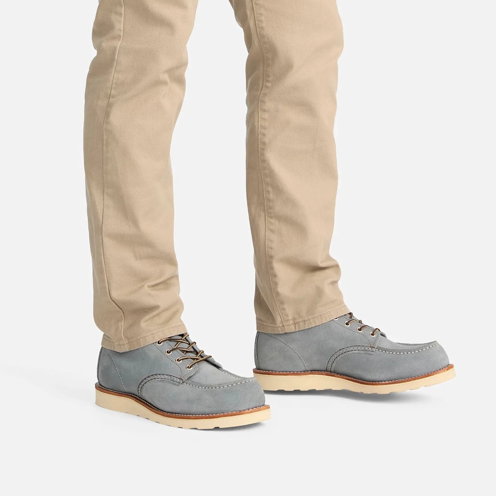 A pair of Red Wing Heritage Classic Moc Boots style 8800 in Dusty Blue was worn by a male wearing khaki-colored pants. The shoes and pants are only shown from just above the knee down. The model is standing with his feet pointed to the right of the image frame.