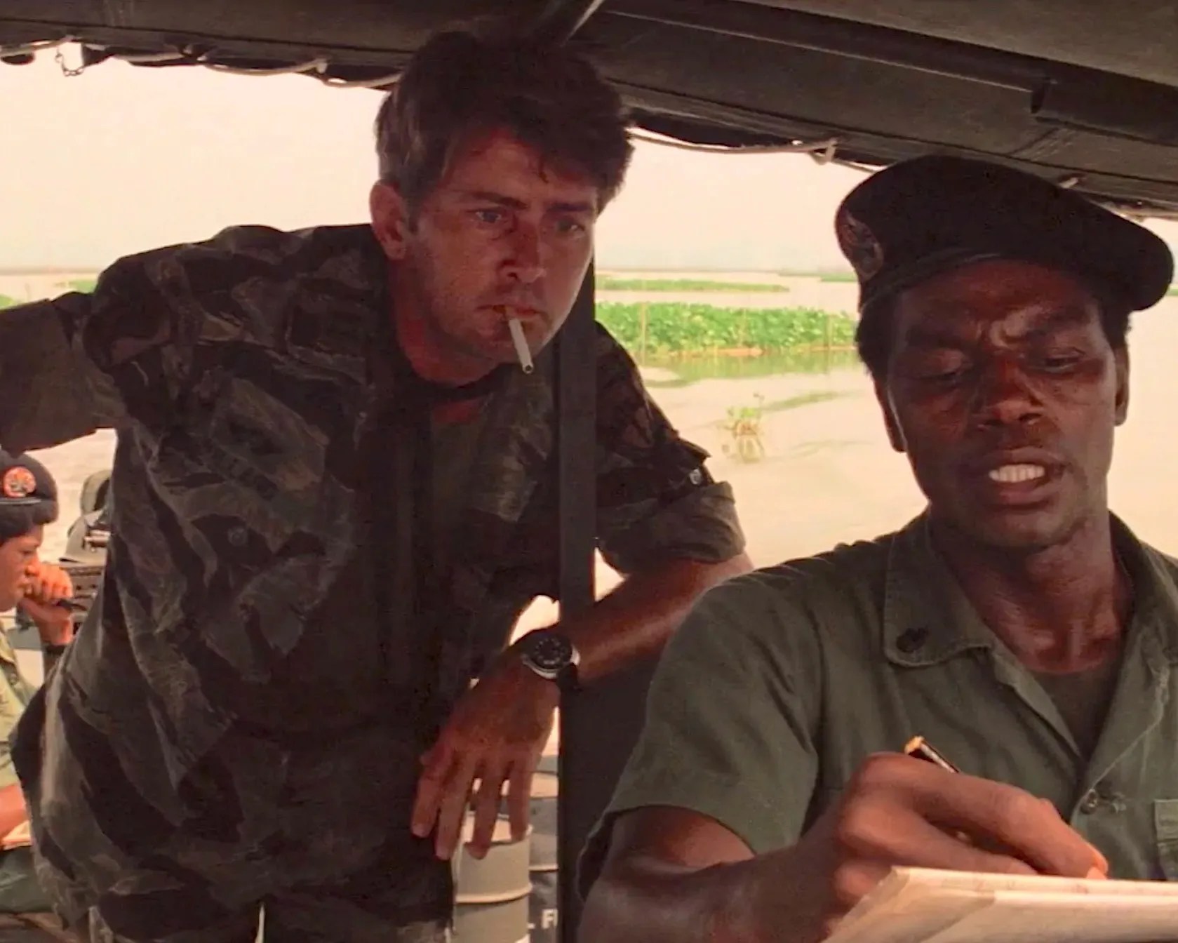 two men stand in a boat cockpit
