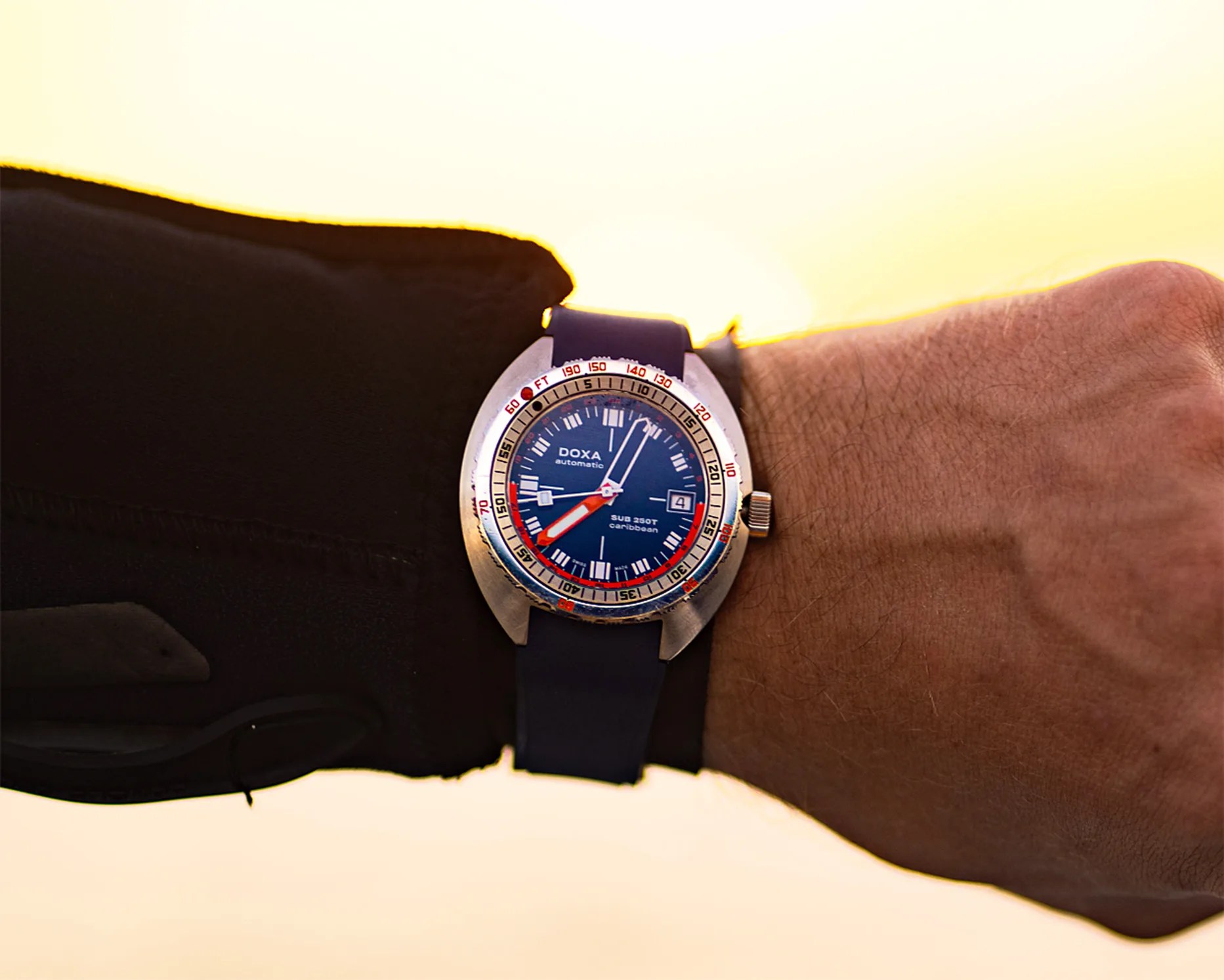 a blue doxa dive watch on a man's wrist