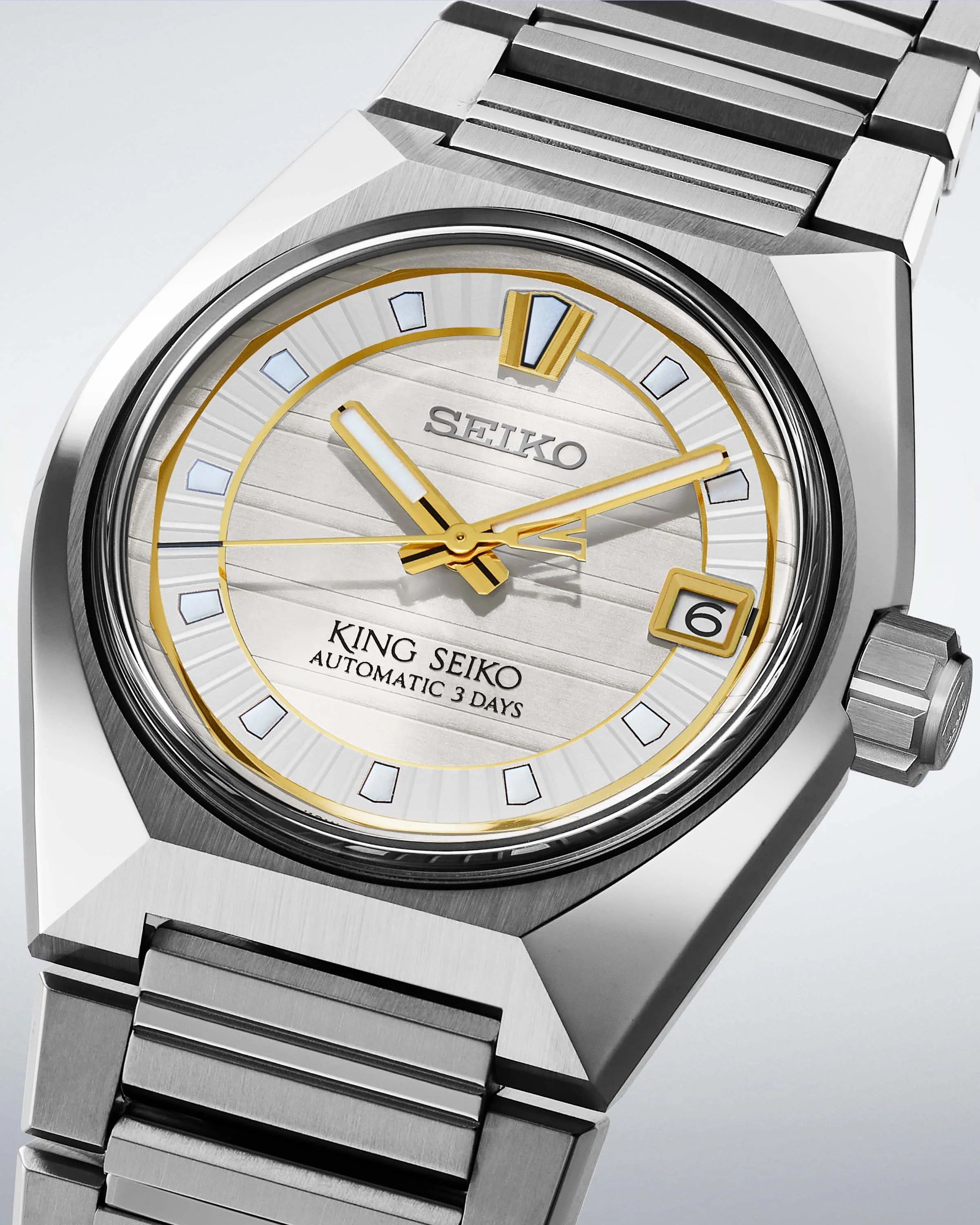 a steel Seiko watch with a white and gold dial