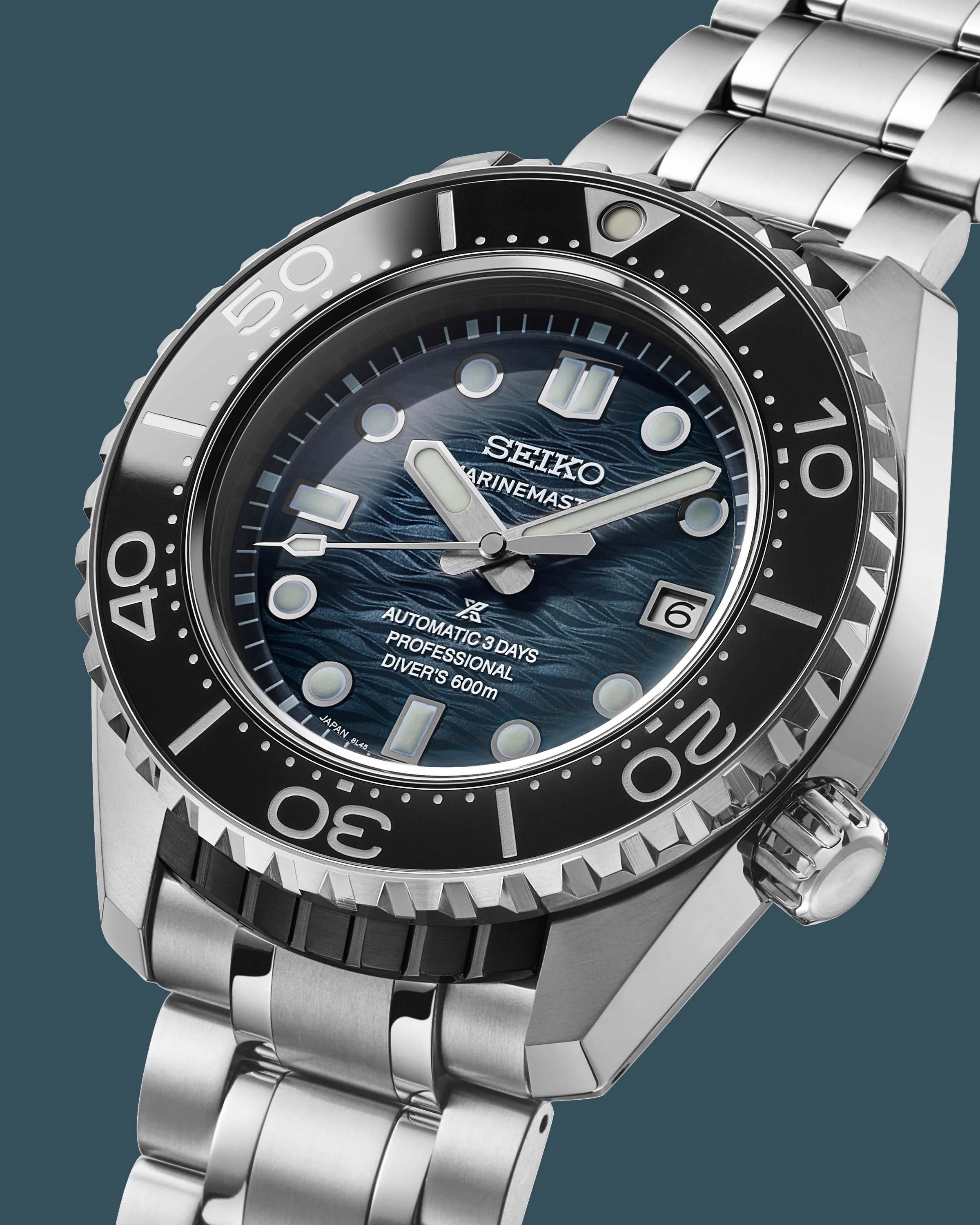 a steel Seiko dive watch with a blue dial and black bezel