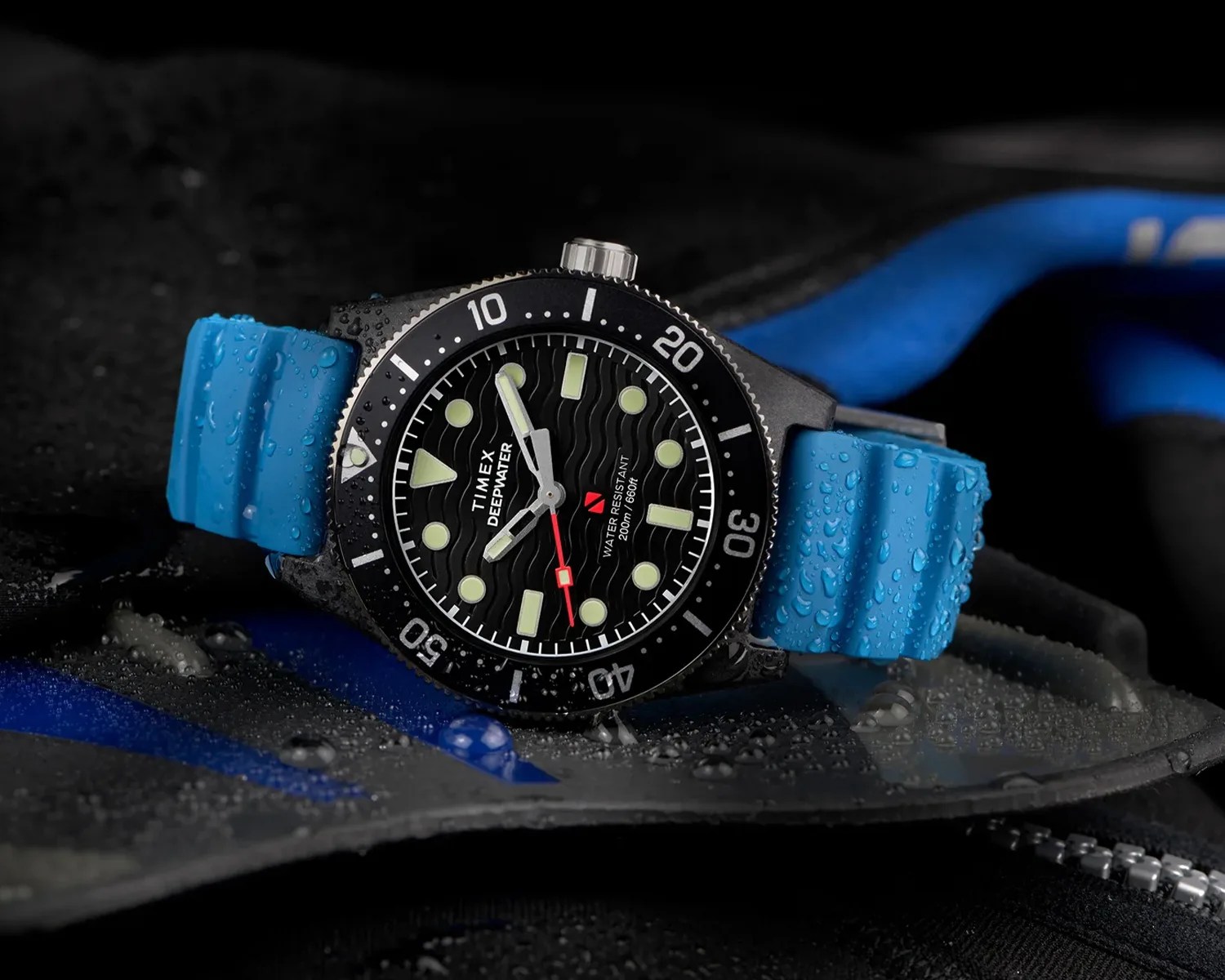 a wet timex dive watch next to some diving equipment