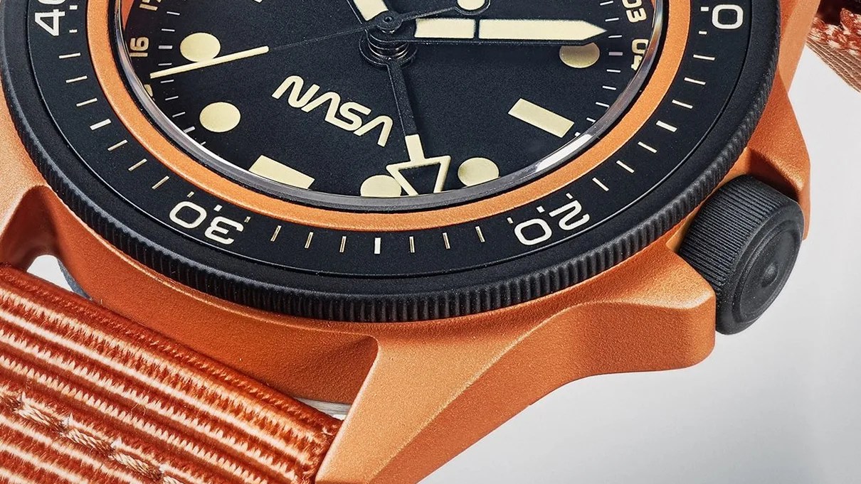 the orange case, black bezel and black crown of a NASA watch