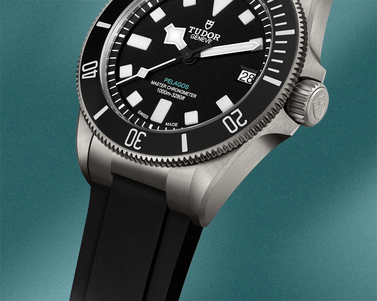 A view of the lower half of the Tudor Pelagos Ultra on a rubber strap against a blurred green background. 